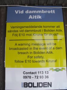 Ein Warnschild für den Fall eines Dammbruches. Zusammenfassung: Fahrt ja so schnell es geht in Richtung Kiruna